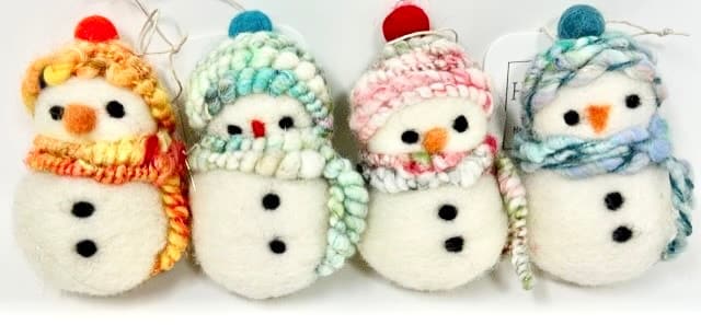 Christmas Markets Massachusetts 2025: Best Festive Events and Holiday Fairs 2 Four handmade felt snowmen ornaments with button eyes, carrot noses, and colorful knit hats and scarves, arranged in a row against a white background.