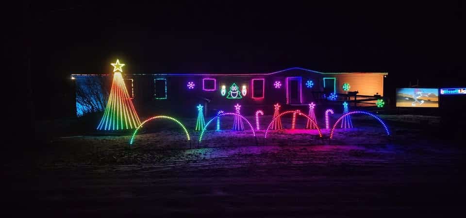 10 Dazzling Christmas Light Shows in Michigan You Can’t Miss in 2025 (Plus Free Spots & Secret Local Favorites!) 3 A house decorated with bright, colorful Christmas lights, including a large tree, arches, and various shapes, glowing vividly at night.
