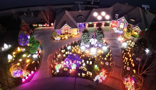 7 Jaw-Dropping Christmas Light Shows in Nebraska You Can’t Miss This Holiday Season (2025 Guide!) 5 A house and yard are decorated with numerous colorful Christmas lights and holiday figures, creating a bright and festive display at night.