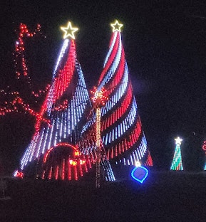 10 Dazzling Christmas Light Shows in Michigan You Can’t Miss in 2025 (Plus Free Spots & Secret Local Favorites!) 1 Two large cone-shaped Christmas light displays with red and white spirals, topped with stars, are surrounded by smaller holiday decorations at night.