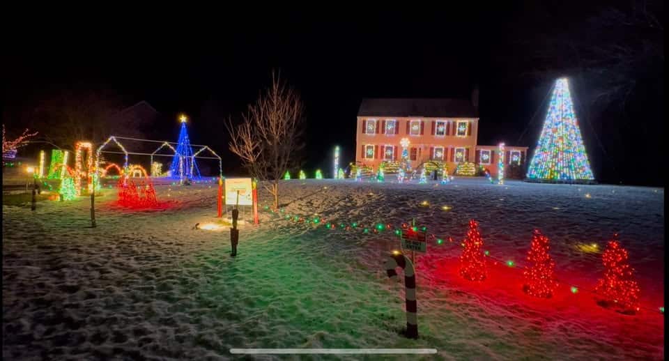 10 Jaw-Dropping Christmas Light Shows in New Hampshire You Can’t Miss in 2025 (With Insider Tips & Hidden Gems!) 5 A house and yard are decorated with colorful Christmas lights, including a large lit tree, small lighted trees, and various illuminated decorations on a snowy lawn.