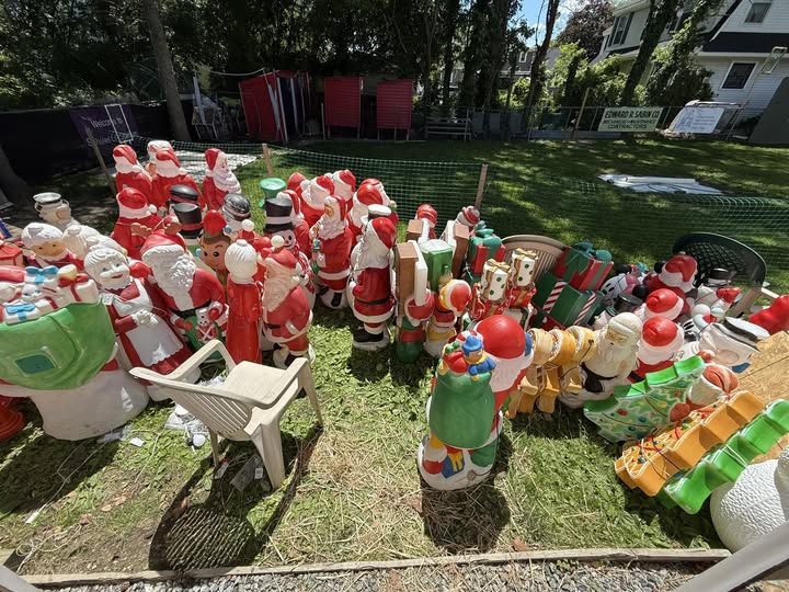 7 Jaw-Dropping Christmas Light Displays in New Jersey That Will Blow Your Mind (And Melt Your Frosty Heart!) 1 A large collection of plastic Santa Claus and holiday figurines displayed outdoors on grass, with some chairs and a house visible in the background.