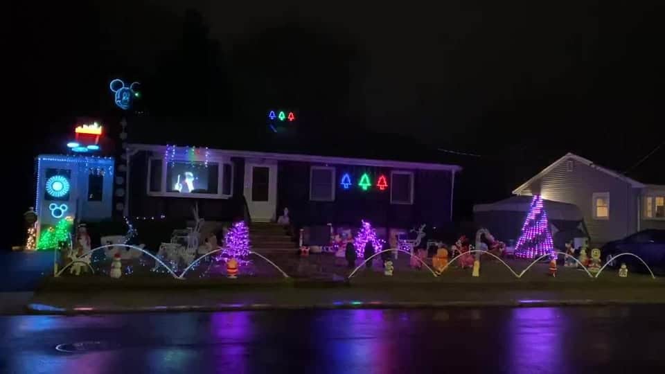 Massachusetts’ Most Magical Christmas Light Displays That Families Can’t Stop Talking About in 2025 3 A house decorated with colorful Christmas lights, holiday figures, and illuminated shapes, with light displays on the roof and front yard, photographed at night.
