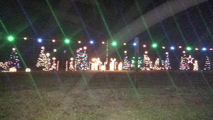 Discover Kentucky’s Jaw-Dropping Christmas Light Spectacles That Will Leave You Breathless This Holiday Season 5 A row of Christmas trees and figures decorated with colorful lights stands outdoors at night, with multicolored lights strung above.