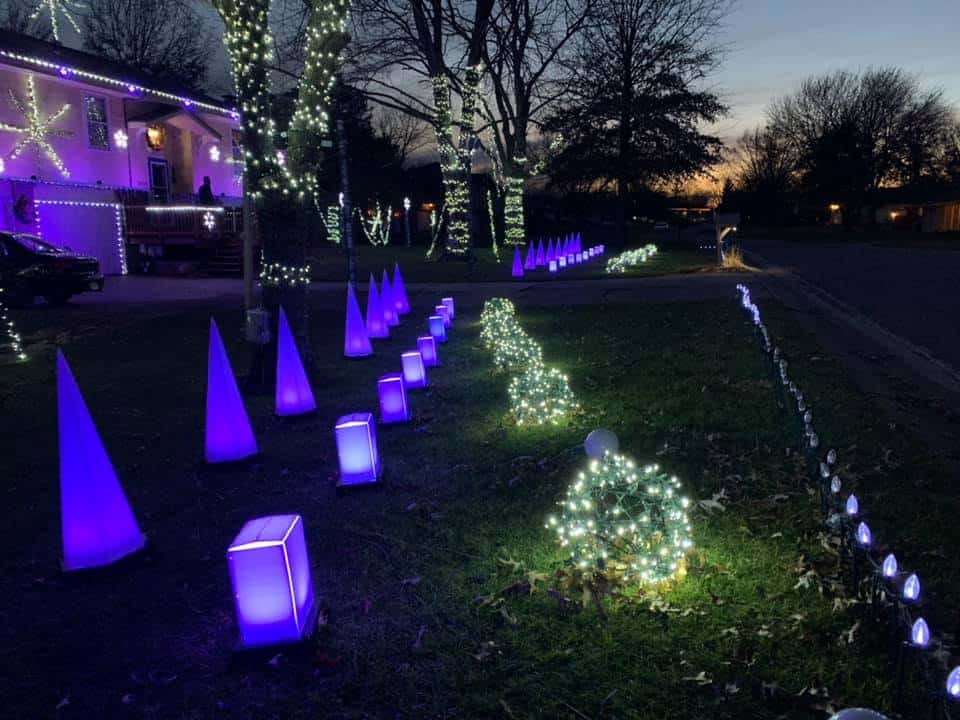 Kansas Christmas Light Shows 2025: The Ultimate Guide to the Most Stunning Holiday Displays You Can’t Miss! 8 Front yard decorated with purple cone lights, illuminated cubes, and glowing wire spheres among trees wrapped in white string lights at dusk.